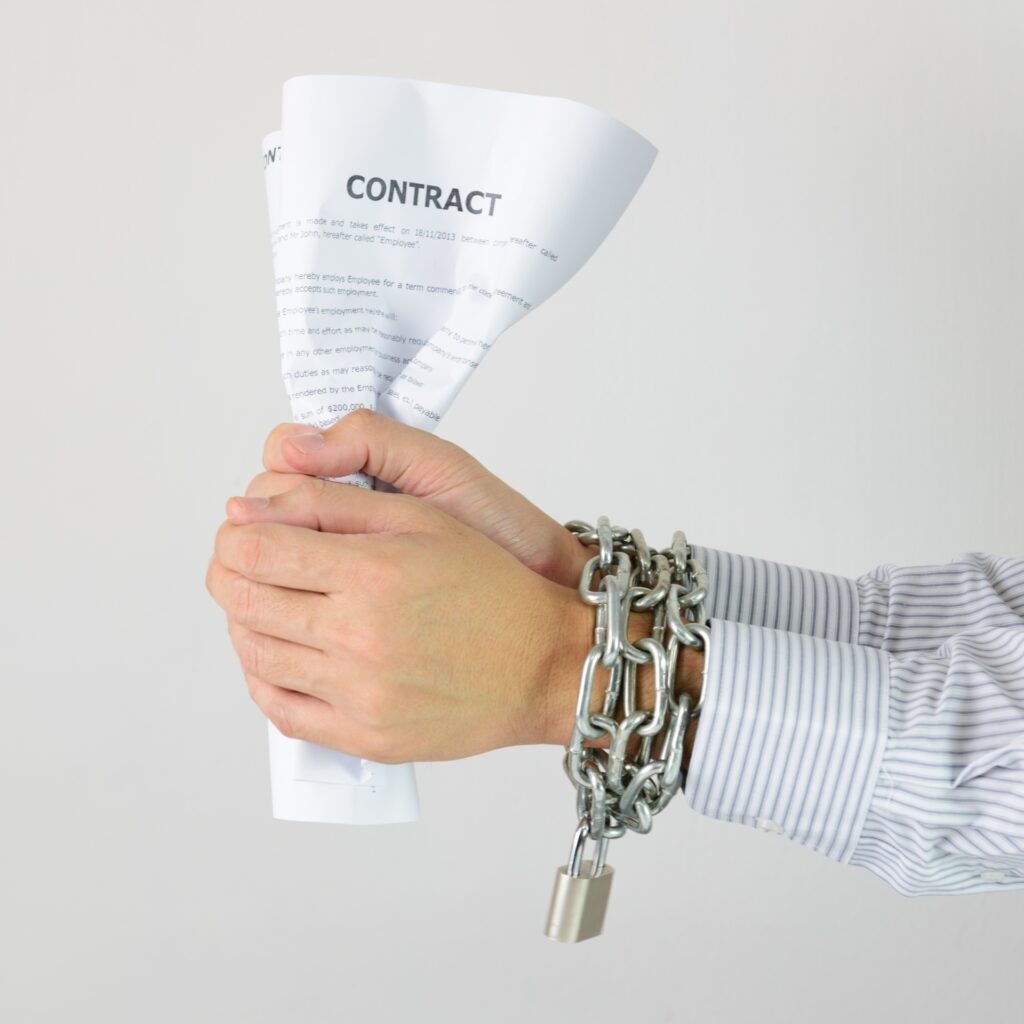 hands chained holding a contract